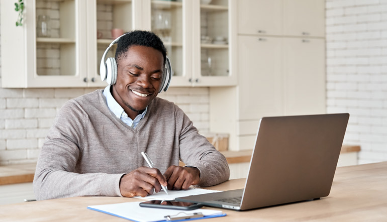 male e-learning on laptop at home