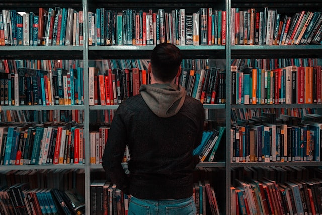 Man standing in front of a library shelf