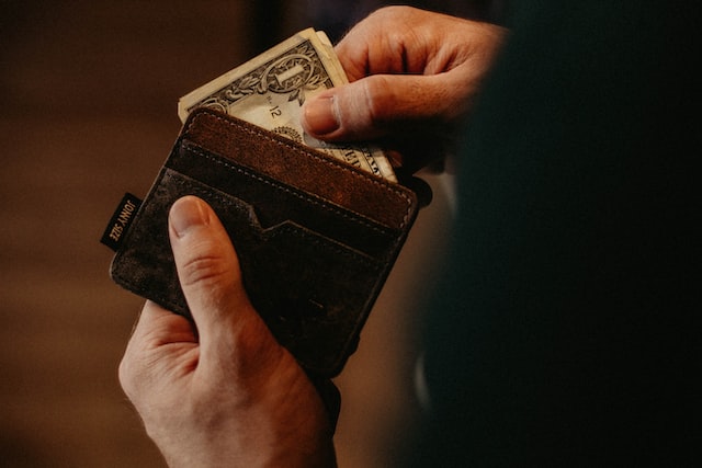 person removing money from a wallet