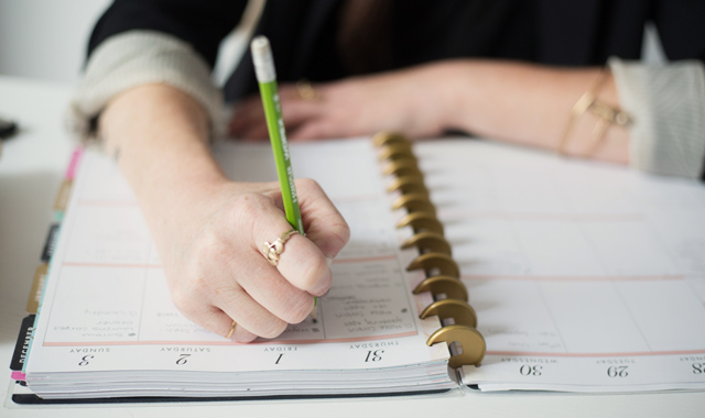 woman writing on planner