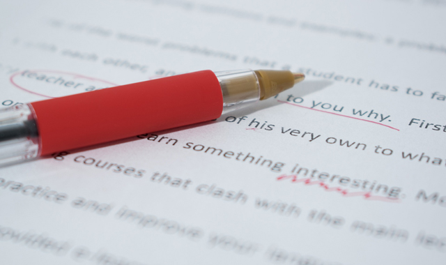 pen on a printed document with red markings