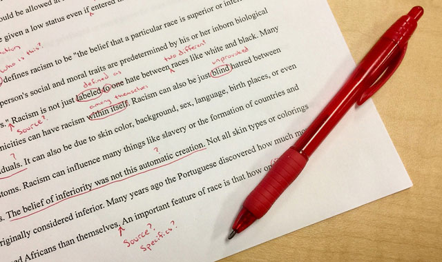 red pen on top of printed paper with corrections