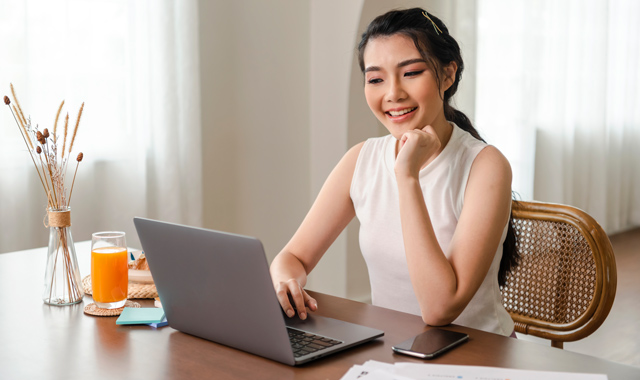 cheerful woman working using her laptop
