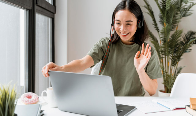 woman with headset having video call on laptop