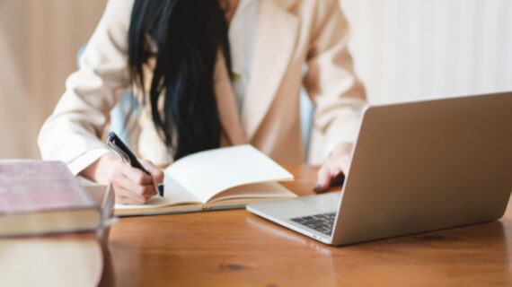 woman writing on her notebook