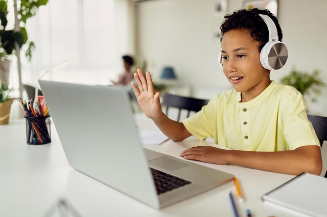 elementary school-kid coding at home with mum in the background