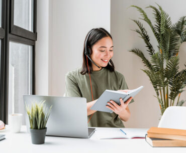 Woman with headset having video call on laptop